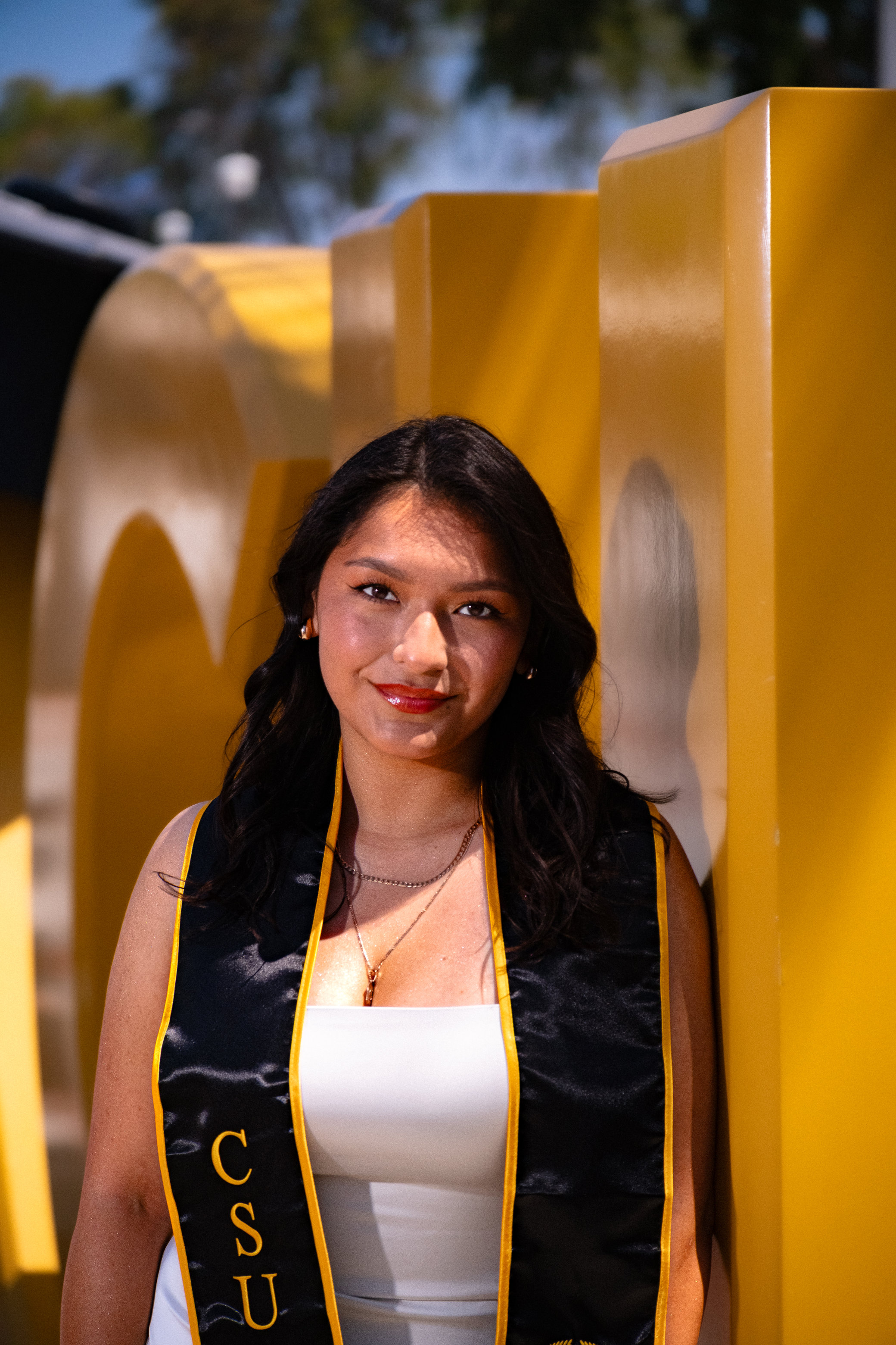 Graduate holding flowers in a sunlit park
