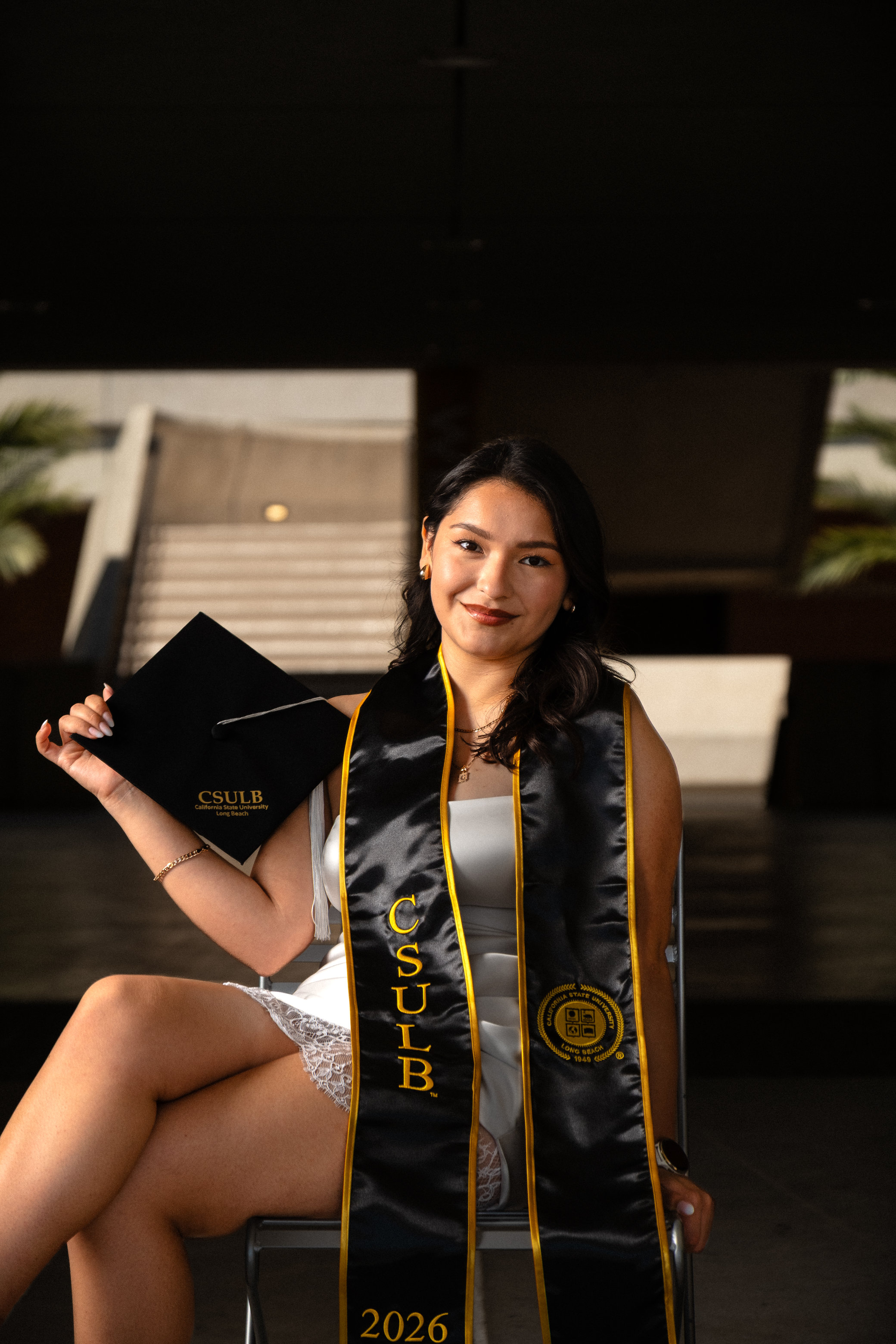 Graduate holding flowers in a sunlit park