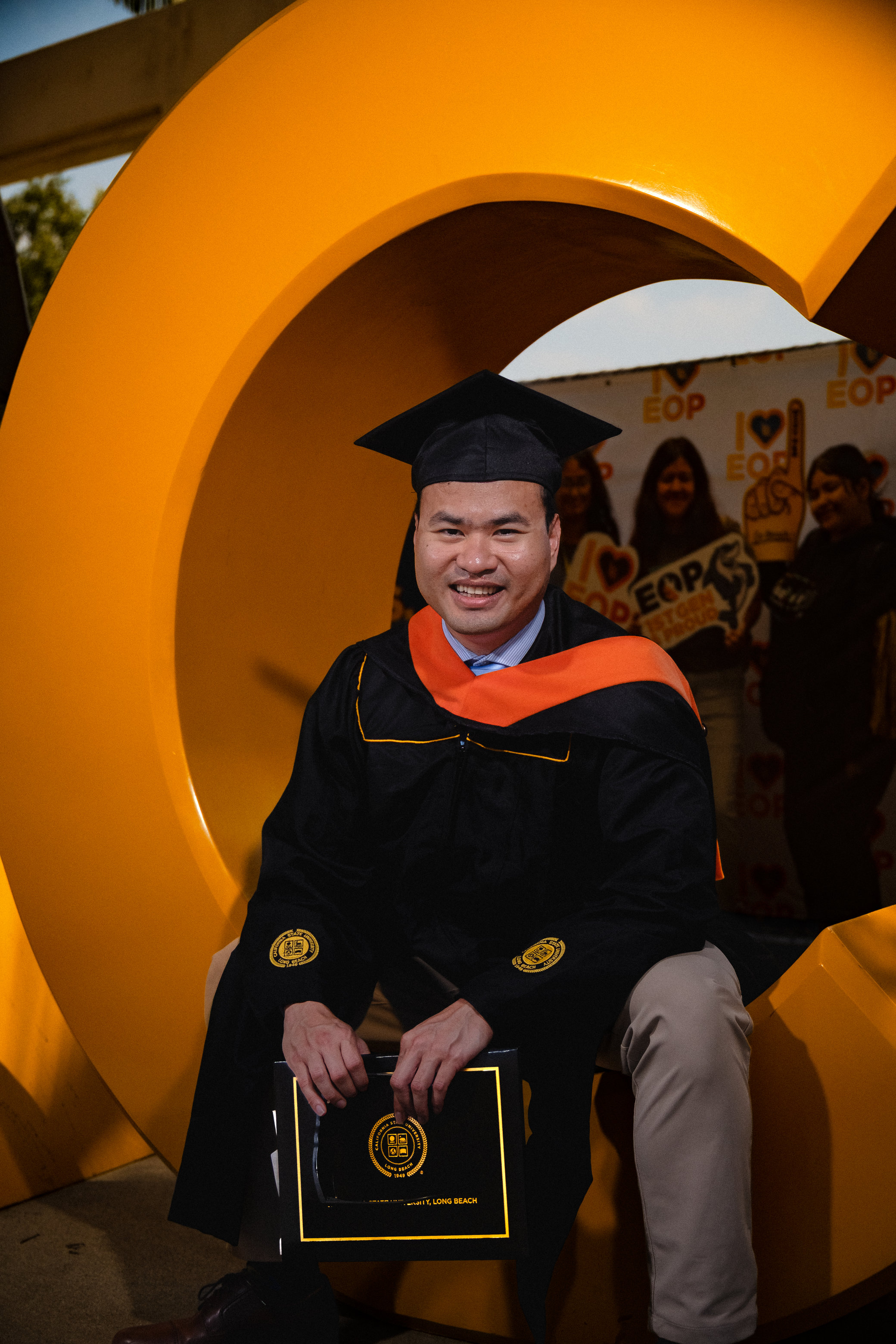 Graduate in a black cap and gown outdoors